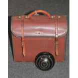 A leather bowls bag containing four lawn bowls signed Hensell & Sons,