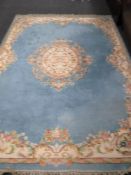 An Oriental fringed woollen carpet on blue ground