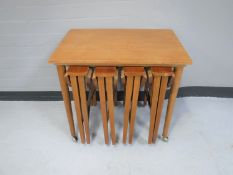 A nest of Danish teak stowaway tables