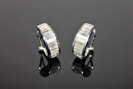 A pair of 18ct white gold diamond earrings, each set with 12 graduated baguette-cut stones,
