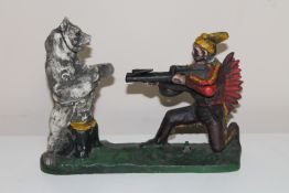 A cast metal novelty money box in the form of a hunter and bear