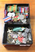 A lacquered box containing a collection of un-named WWII medals, foreign medals,