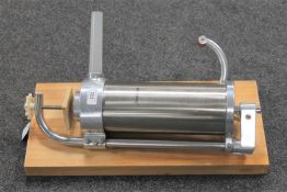 A King Hoff stainless steel sausage maker together with a wooden board