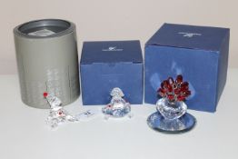 Three Swarovski ornaments; Seated clown, Seated girl wearing frock and a flower vase, all boxed.