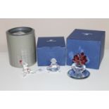 Three Swarovski ornaments; Seated clown, Seated girl wearing frock and a flower vase, all boxed.