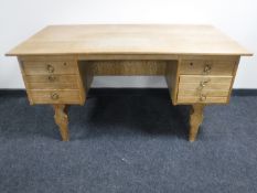A continental light oak pedestal desk fitted six drawers