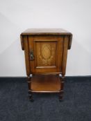 A Victorian inlaid mahogany flap sided bedside cabinet