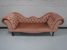 An antique style scroll ended button settee