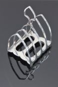 A George V silver toast rack, having Gothic-arch divisions and inverted open spade-form handle,