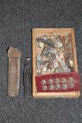 A wooden tray containing various wristwatches, military buttons,