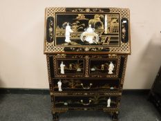 A Japanese lacquered bureau with mother of pearl figures