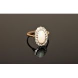 An opal and diamond cluster ring, a large cabochon opal within a border of old cut diamonds,