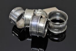 Six silver napkin rings including a matching pair.