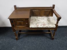 A carved oak linen fold telephone seat