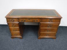 A Victorian style pedestal desk with green leather insert