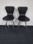 A pair of black leather chrome bar stools