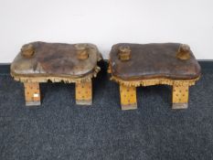 A pair of Eastern style leather topped footstools