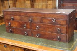 An antique multi drawer chest with lift-up lid together with a wicker basket containing an