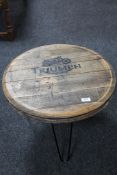 An occasional table with whisky barrel top depicting a Triumph motorcycle