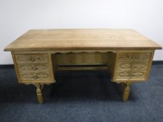 A light oak pedestal desk fitted with six drawers
