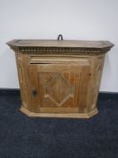 An antique light oak carved wall cabinet