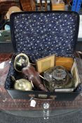 A vintage suitcase containing wooden elephant ornament, silver plated items,