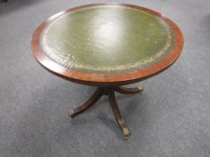 A circular mahogany wine table inset leather panel