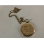 A 9ct gold circular locket on yellow metal chain.