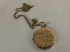 A 9ct gold circular locket on yellow metal chain.