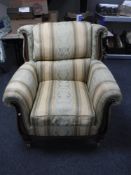 A wood framed armchair in a regency style fabric
