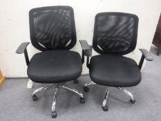 A pair of black office armchairs