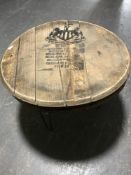 A whiskey barrel lid coffee table bearing Newcastle United logo on metal legs