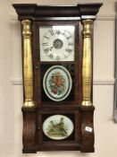 A mahogany cased wall clock with gilt pillars and decorative oval panel,