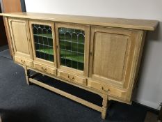 A blonde oak four door sideboard