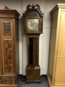 A Grandfather clock in carved oak case, with brass and silvered dial, with pendulum and weights,
