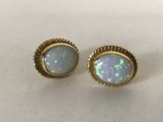 A pair of yellow gold mounted opal earrings.