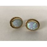 A pair of yellow gold mounted opal earrings.