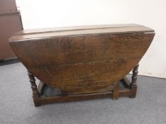 An antique oak gate leg table fitted two drawers