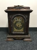 A carved oak chiming bracket clock with brass dial