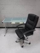 A metal glass top computer desk and a high back armchair