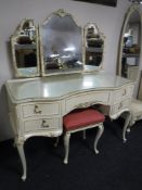 A cream and gilt shaped dressing table with triple mirror and stool