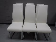 A white high gloss dining table (dismantled) and six white vinyl high backed dining chairs