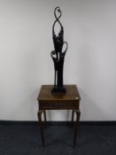 An Edwardian oak occasional table and a contemporary figure depicting an elephant group