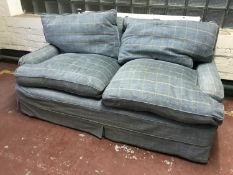 A two seater settee upholstered in checked loose covers