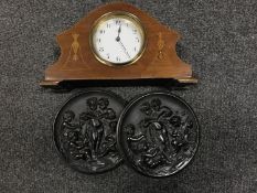 A French inlaid mahogany eight day mantel clock and a pair of carved ebonised wall plaques of