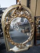 A gilt framed arched sectional mirror with shelf and a gilt Rococo style mirror