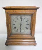 An early 20th century oak cased mantel clock with silvered dial