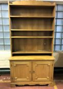 A set of blonde oak open bookshelves fitted double door cupboard beneath