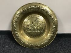 A circular brass embossed plaque depicting Boadicea on a chariot