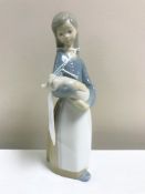 A Lladro figurine : Girl Holding a Pig, model 1011, height 17 cm, boxed.